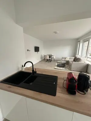 a kitchen with a sink and a living room at Luxury 2BR Apartment Heart of Mechelen in Mechelen