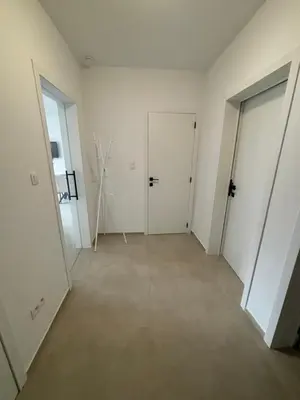 an empty room with white walls and two doors at Luxury 2BR Apartment Heart of Mechelen in Mechelen
