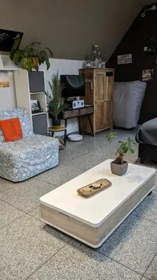 a living room with a bed and a chair at De Boskouter - studio - op het platteland - hondvriendelijk - gastvrij in Geraardsbergen