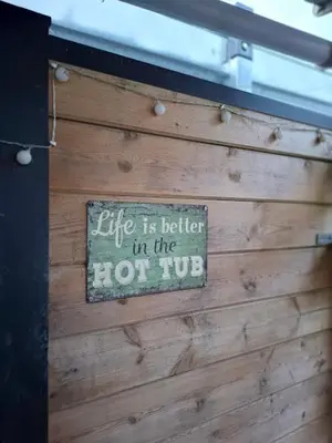 a sign on a wooden wall saying life is better in the hot hog at De Boskouter - studio - op het platteland - hondvriendelijk - gastvrij in Geraardsbergen