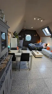 a living room with a couch and a table at De Boskouter - studio - op het platteland - hondvriendelijk - gastvrij in Geraardsbergen