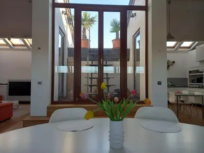 a white table with a vase of flowers on it at Panorama Vue Penthouse in Brussels