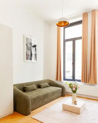 a living room with a couch in front of a window at 1 Bdr flat met cozy mezzanine in Antwerp
