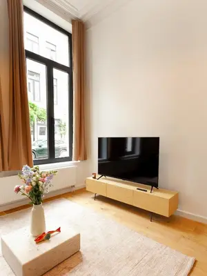 a living room with a large flat screen tv at 1 Bdr flat met cozy mezzanine in Antwerp
