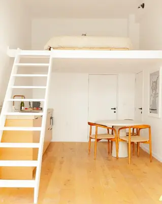 a bedroom with a bunk bed and a table with a tablektop at 1 Bdr flat met cozy mezzanine in Antwerp