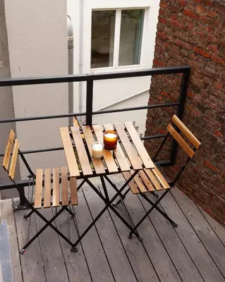 a wooden table and two chairs on a balcony at 1 BR Stylish flat with balcony in Antwerp