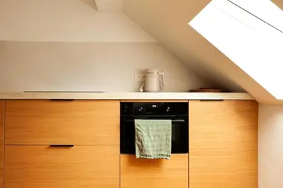a kitchen with wooden cabinets and a stove at Cozy 1BDR Topfloor duplex flat in Antwerp