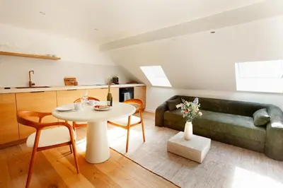 a living room with a table and a couch at Cozy 1BDR Topfloor duplex flat in Antwerp