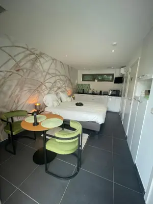 a bedroom with a bed and two tables and chairs at Q Studio Green in Herzele