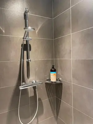 a shower with a shower head in a bathroom at Q Studio Green in Herzele