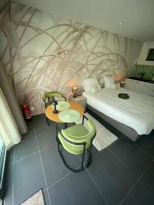 a hotel room with a bed and a table and chairs at Q Studio Green in Herzele