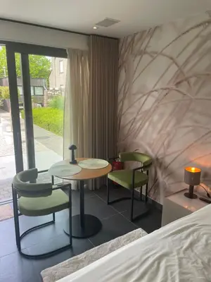 a bedroom with two chairs and a table and a bed at Q Studio Green in Herzele