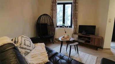 a living room with a couch and a table at Gite de l'oseraie