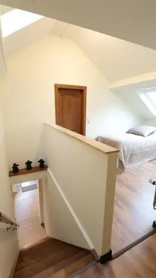 a attic room with two beds and a table at Gite de l'oseraie