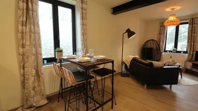 a living room with a table and chairs and a couch at Gite de l'oseraie