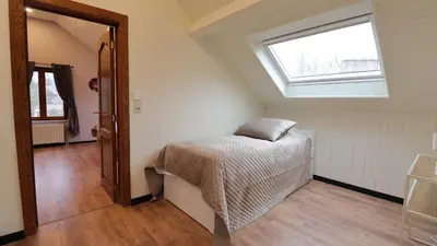 a bedroom with a bed and a window at Gite de l'oseraie