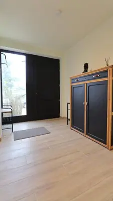 an empty room with a large window and a large door at Gite de l'oseraie