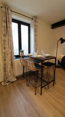 a dining room with a table and chairs and a window at Gite de l'oseraie