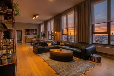 a living room with a couch and a table at Sunset Penthouse Antwerp in Antwerp