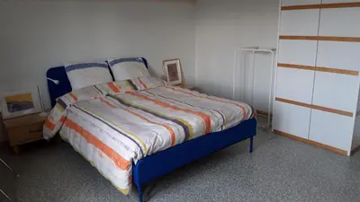 a bedroom with a bed and a white wall at Villa in Diest nabij het groen in Diest