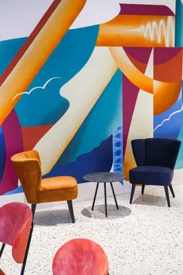 a group of chairs and a table in front of a mural at BX Downtown - Brussels in Brussels