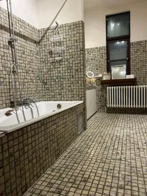 a bathroom with a tub and a tile floor at Luxury suite with a private terrace in Diest
