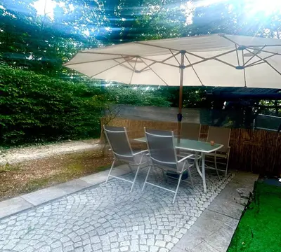 a table and chairs with an umbrella on a patio at Luxury suite with a private terrace in Diest