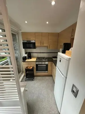 a kitchen with wooden cabinets and a white refrigerator at Comfortable Apartment in Brussels, 35 m², 3 Persons in Brussels