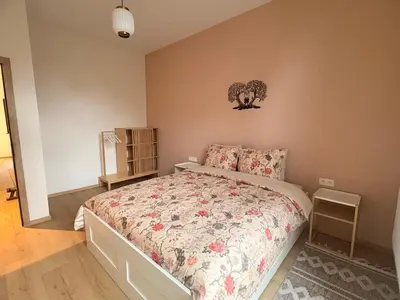 a bedroom with a bed with a floral bedspread at Le Goujons - New apartment near Midi Station in Brussels