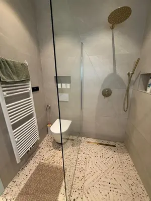 a bathroom with a glass shower and a toilet at Le Goujons - New apartment near Midi Station in Brussels