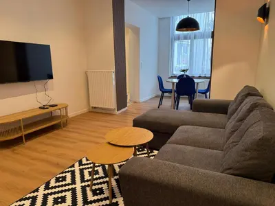 a living room with a couch and a table at Le Goujons - New apartment near Midi Station in Brussels