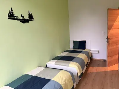 a bedroom with two beds and a wall at Le Goujons - New apartment near Midi Station in Brussels