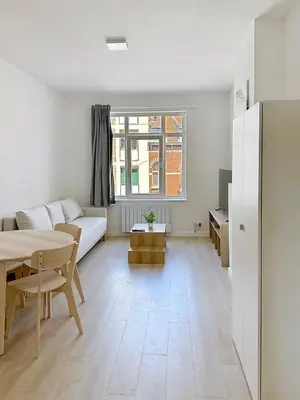 a living room with a table and a couch at Élégant appartement une chambre in Brussels