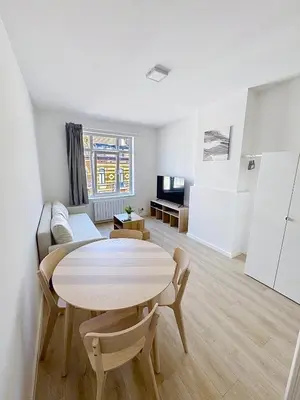 a living room with a table and a couch at Élégant appartement une chambre in Brussels
