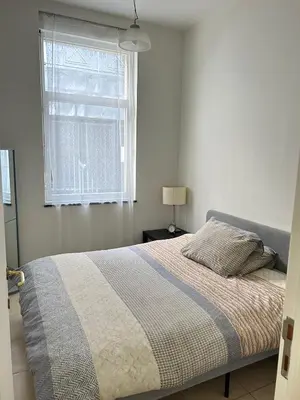 a bed in a white bedroom with a window at The Heart of Petit Sablon in Brussels