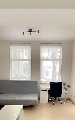 a bedroom with a bed and a desk and two windows at The Heart of Petit Sablon in Brussels