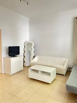 a living room with a white couch and a tv at The Heart of Petit Sablon in Brussels