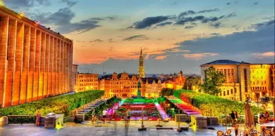 a city skyline with a fountain in front of a building at The Heart of Petit Sablon in Brussels