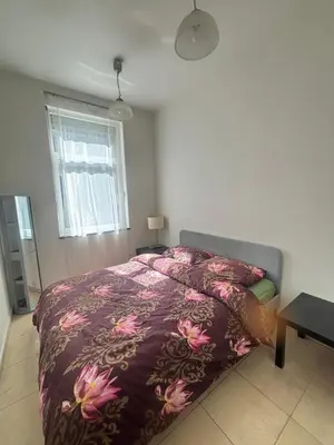 a bedroom with a bed with a purple comforter at The Heart of Petit Sablon in Brussels