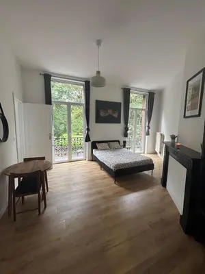 a living room with a bed and a table at Studio Lilia in Brussels