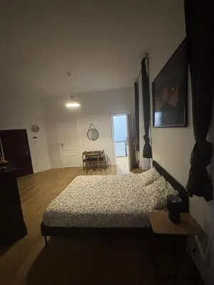 a bedroom with a bed and a table in it at Studio Lilia in Brussels