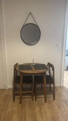 a table with two chairs and a mirror on the wall at Studio Lilia in Brussels