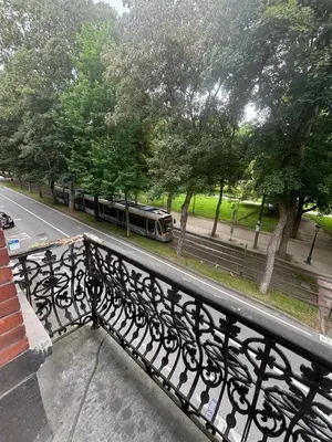 a bench on a balcony with a train on the street at Studio Lilia in Brussels