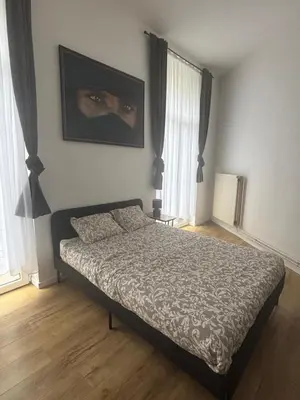 a bedroom with a bed with a mask on the wall at Studio Lilia in Brussels