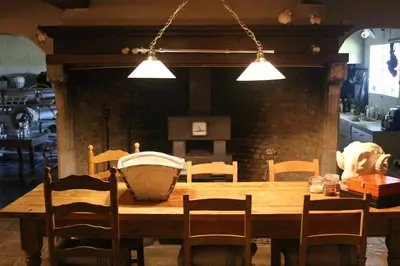 a dining room table with chairs and a kitchen at Gastenlogies Blauwe Schaap in Ranst