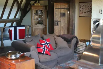 a living room with a grey couch with red pillows at Gastenlogies Blauwe Schaap in Ranst