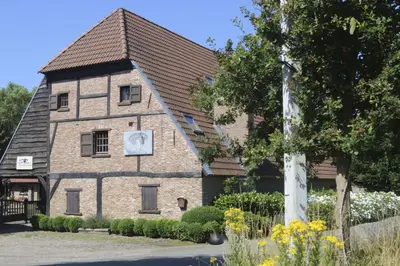 a building with a clock on the side of it at Gastenlogies Blauwe Schaap in Ranst