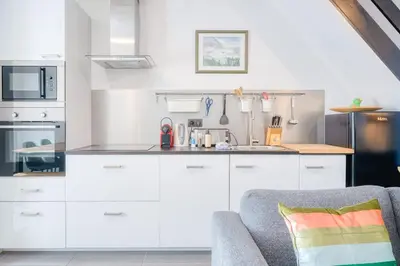 a kitchen with white cabinets and a gray couch at Charming & Central Stay with Terrace in Ghent