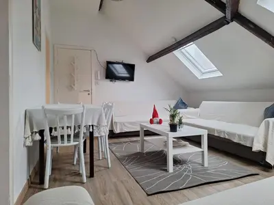 a living room with a table and a white couch at Cozy Nest by Gare du Midi in Brussels