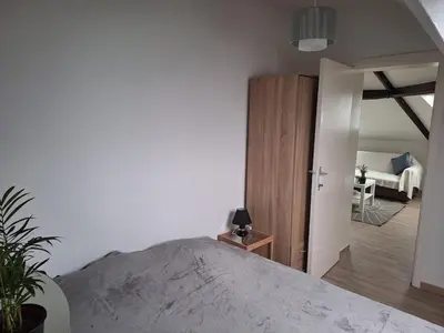 a bedroom with a large bed and a room with a couch at Cozy Nest by Gare du Midi in Brussels